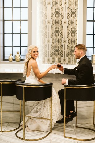Bride and groom happily toast at wedding reception bar