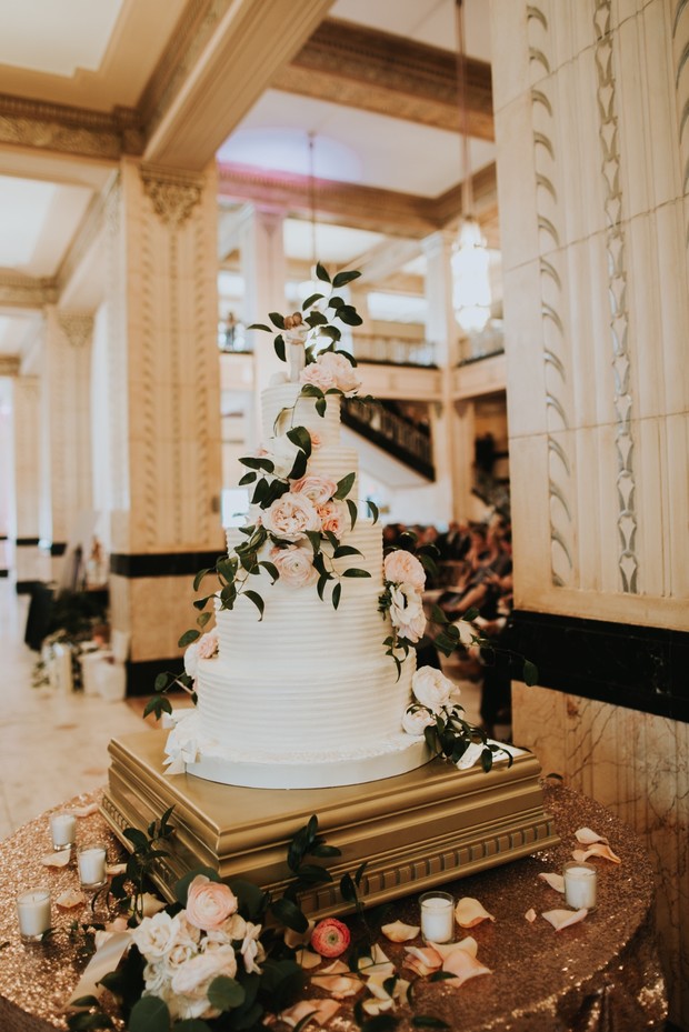Elegant white wedding cake with pink roses floral design