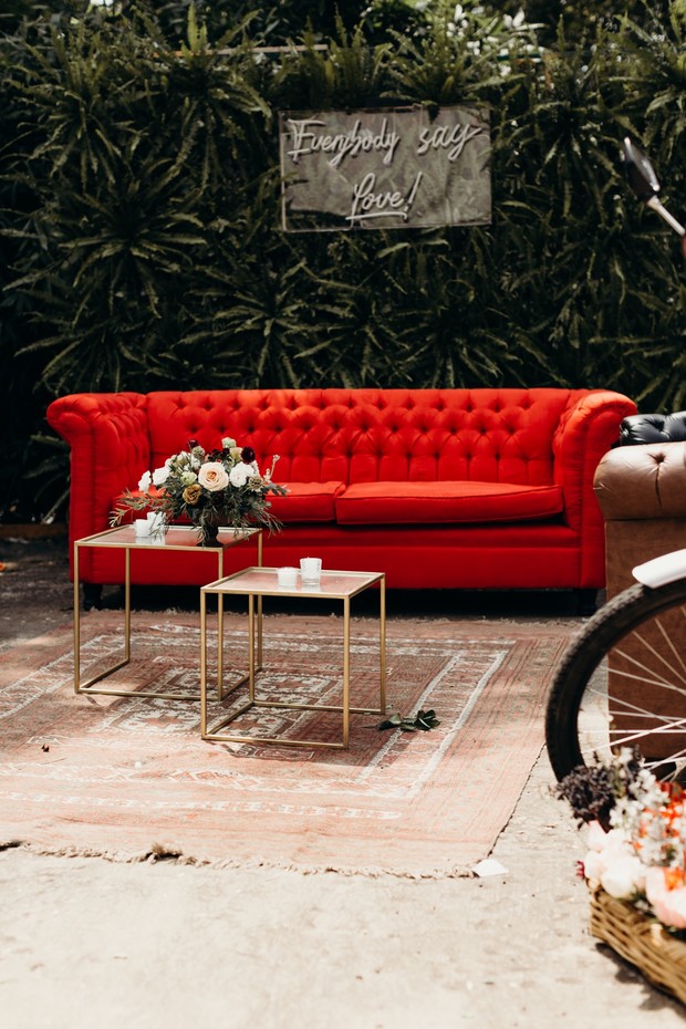 Elegant outdoor setting with red sofa and love decor