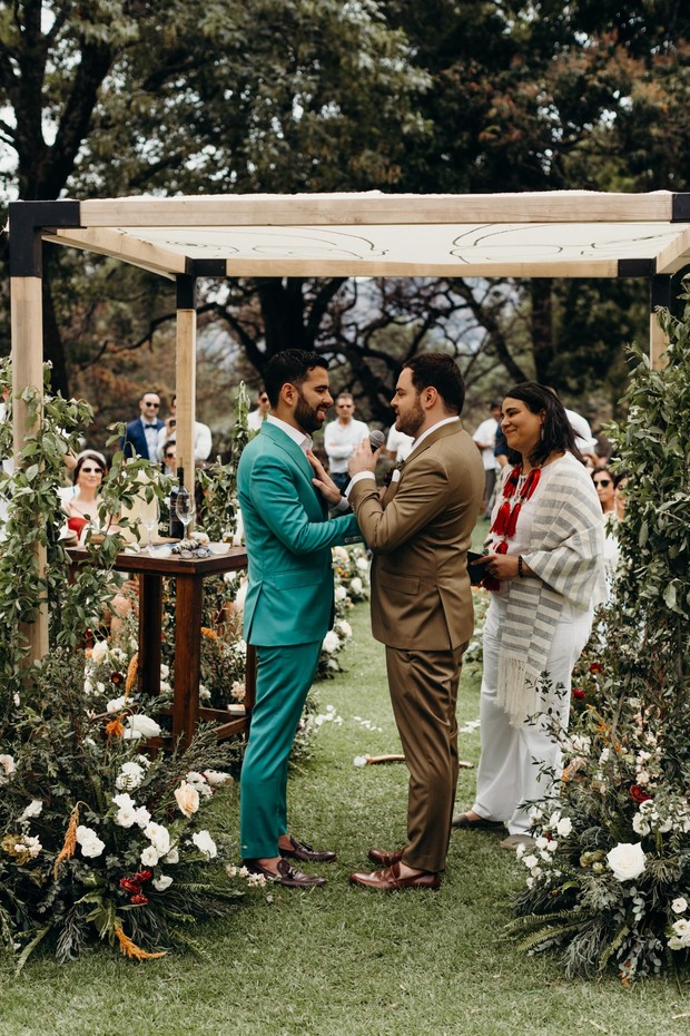 Grooms exchanging vows at outdoor wedding ceremony