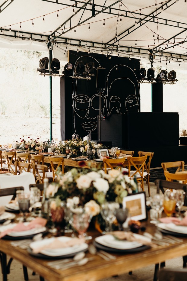 Wedding reception with floral centerpieces and custom backdrop