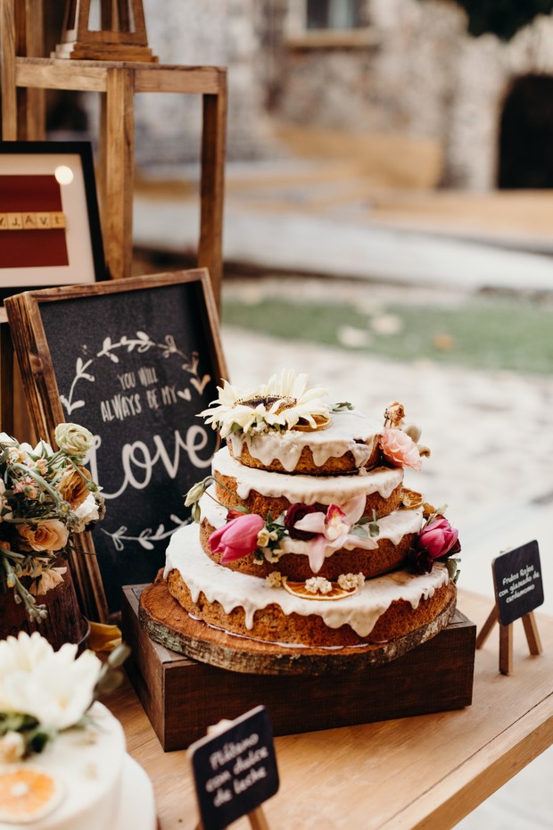 Rustic tiered cake with white icing and flower decorations