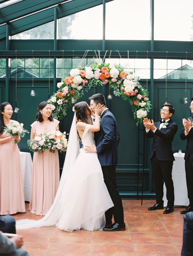Bride and groom kissing at their greenhouse wedding