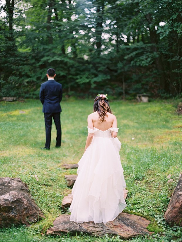 Bride walking toward groom for first look outdoors
