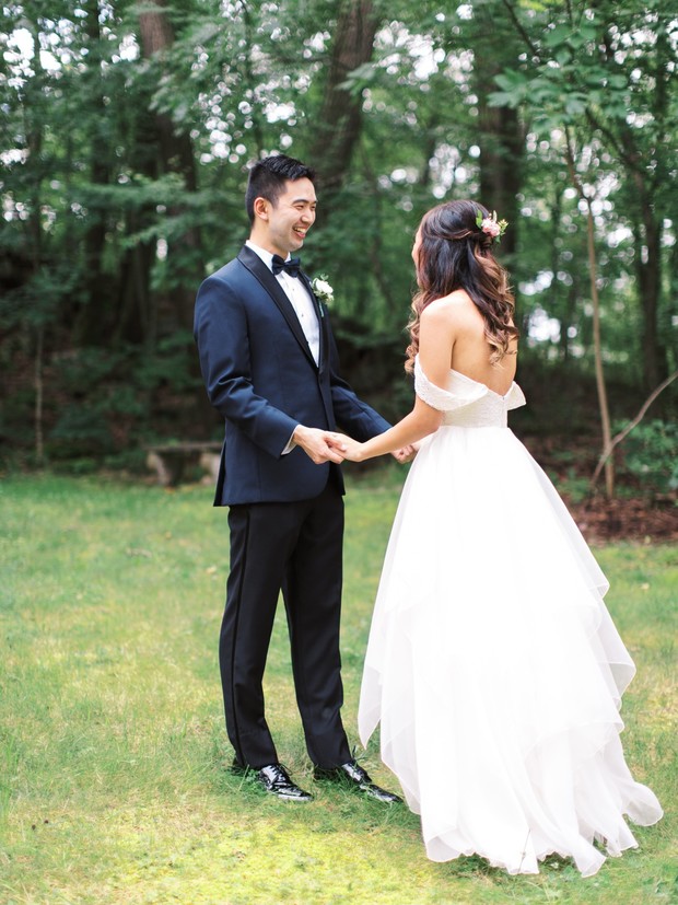 Happy bride and groom hold hands at their outdoor wedding