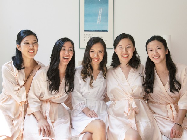 Bride and bridesmaids in robes smile before wedding