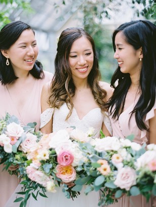 Smiling bride and bridesmaids with floral bouquets