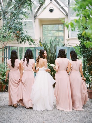 Bride and bridesmaids in blush dresses at greenhouse