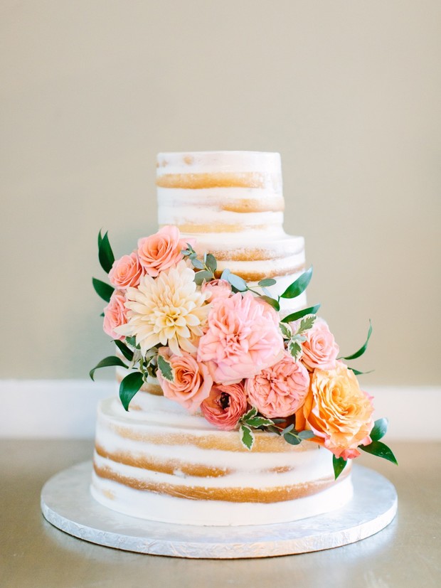 Rustic naked wedding cake adorned with beautiful fresh flowers