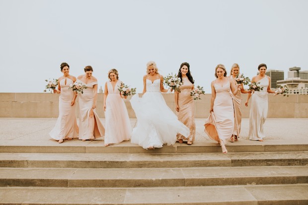 Wedding bride and bridesmaids in dresses walking stairs