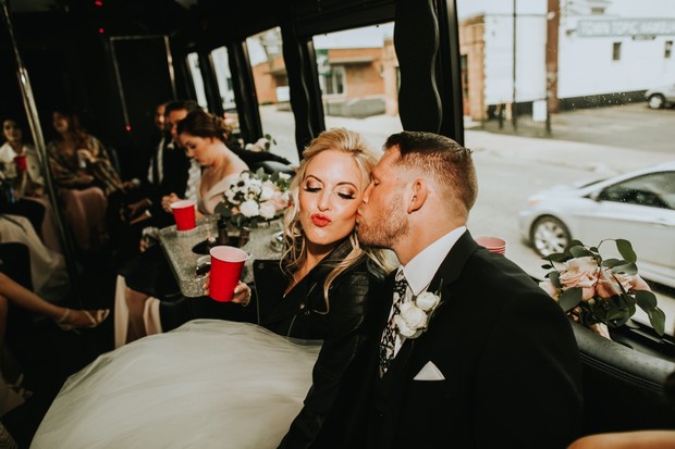 Groom kisses bride in party bus wedding celebration
