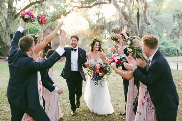 Bride and groom walk through cheering wedding guests