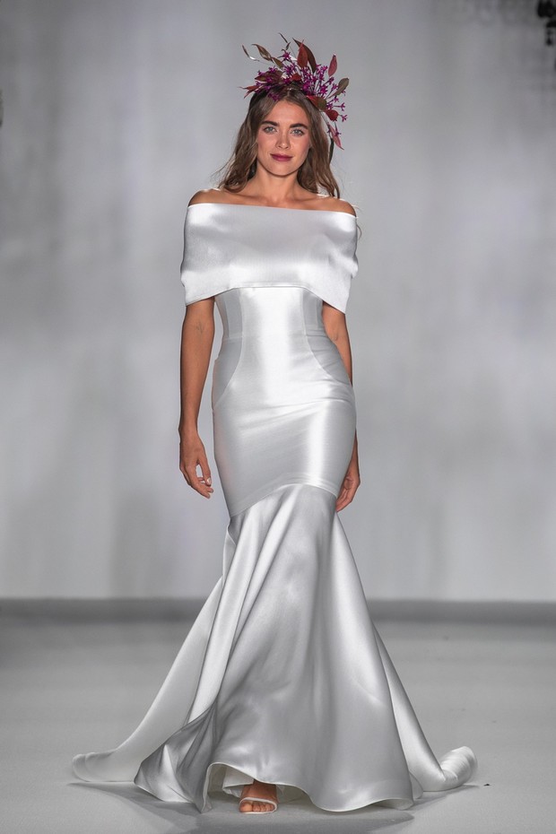 Woman in white off shoulder wedding gown on the runway