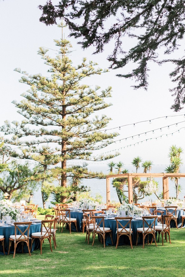 Outdoor wedding reception with blue tablecloths and chairs