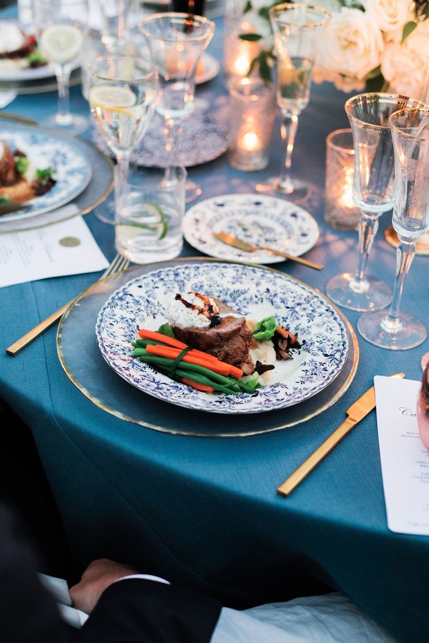 Elegant dinner setting with blue tablecloth and gold cutlery
