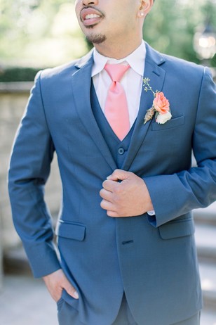 groom in blue suit and coral tie