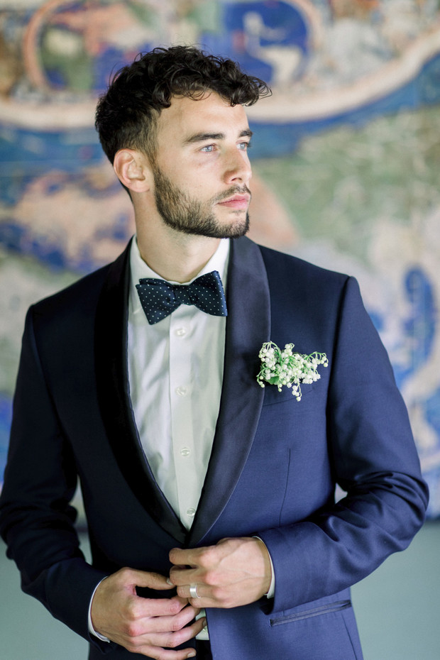 groom in navy suite and polka dot bow tie