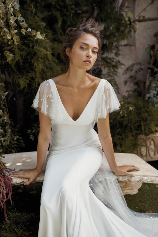 Elegant bride in a simple white wedding dress outdoors