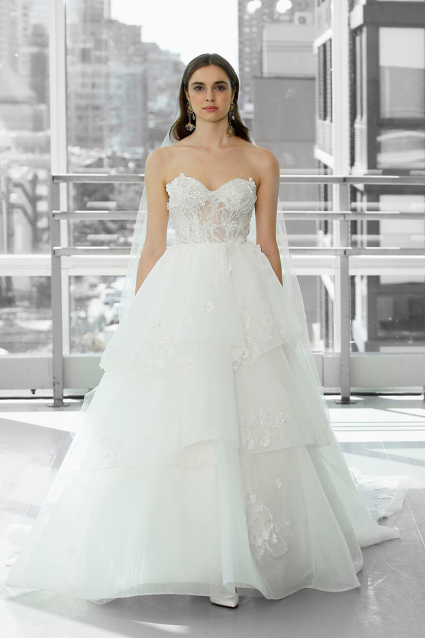 Elegant strapless wedding dress with layered skirt and veil