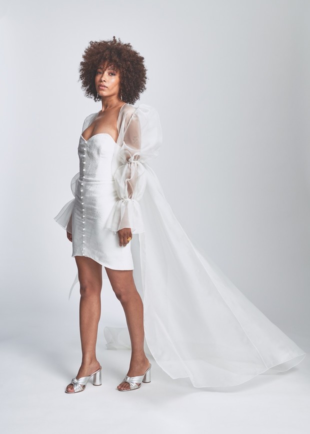 Woman in stylish white mini wedding dress with sheer train