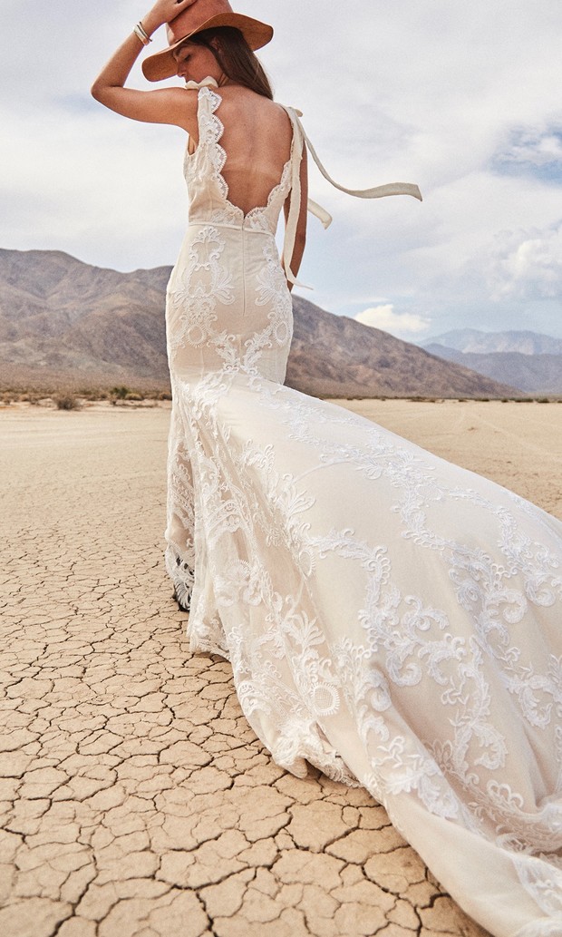 Boho bride in lace wedding dress at desert landscape