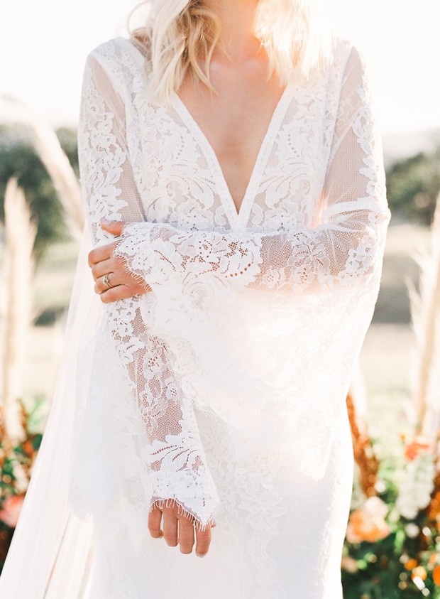 Bride in elegant lace wedding dress with bell sleeves