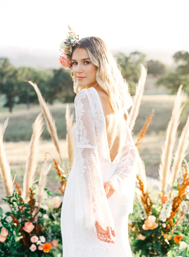 Beautiful bride in lace gown with floral crown outdoors