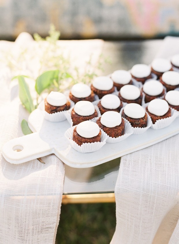 Mini brownies topped with marshmallow frosting on a platter