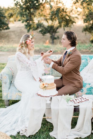 Bride and Groom share cake at outdoor wedding reception