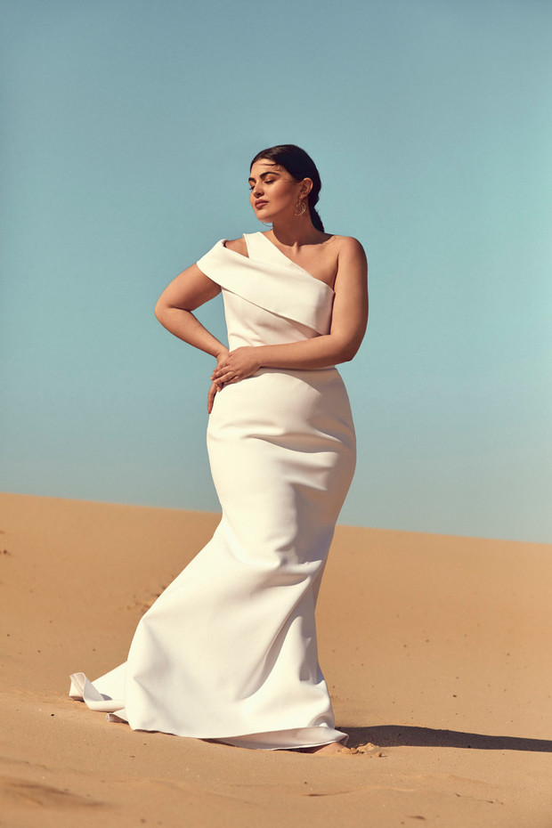 Woman in elegant white dress posing in the desert landscape