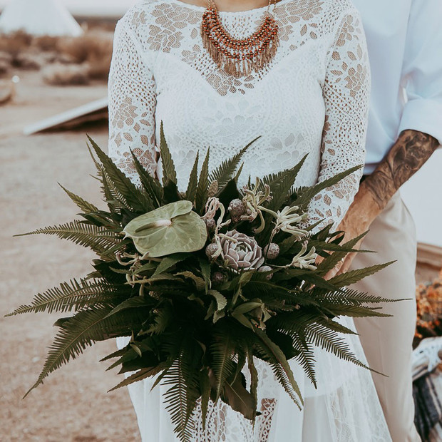 Bride holding a beautiful bouquet at a desert wedding ceremony