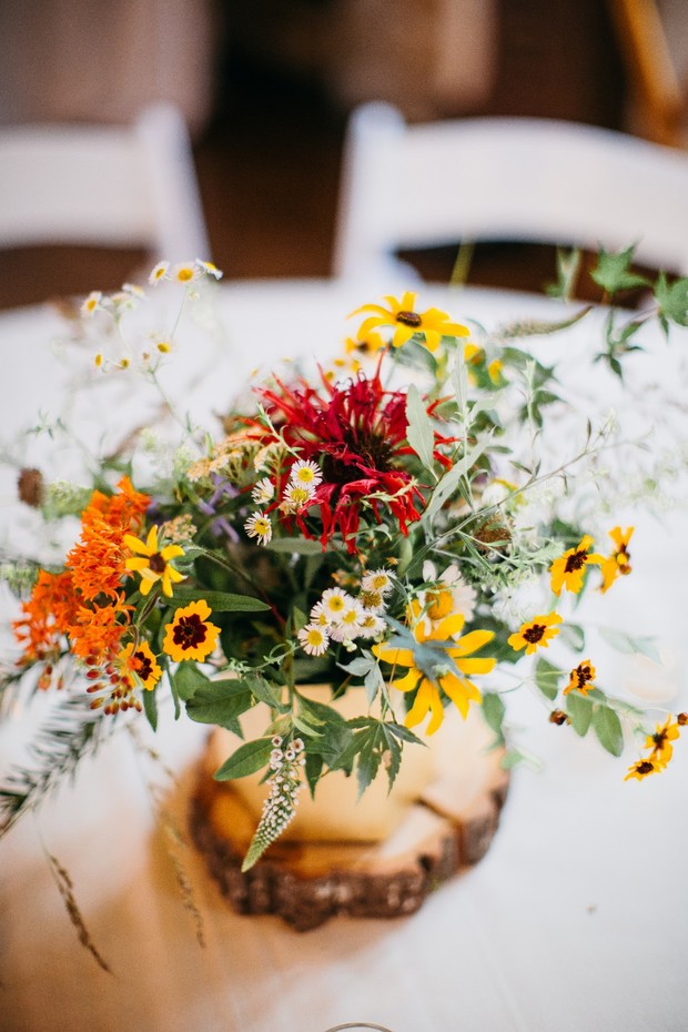 Colorful floral centerpiece displayed on a rustic wood slice
