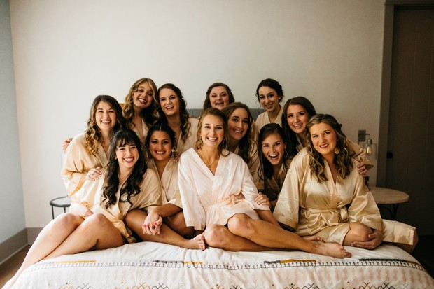 Happy bridesmaids in silk robes posing for wedding photo