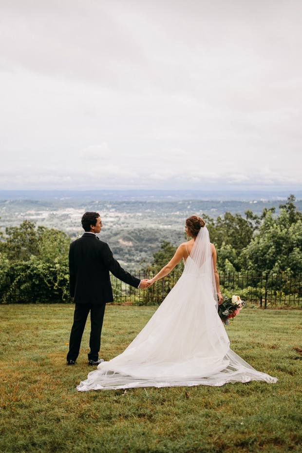 Newlyweds holding hands overlooking a beautiful scenic landscape