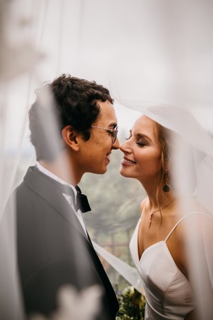Newlywed couple shares an intimate moment under a sheer veil