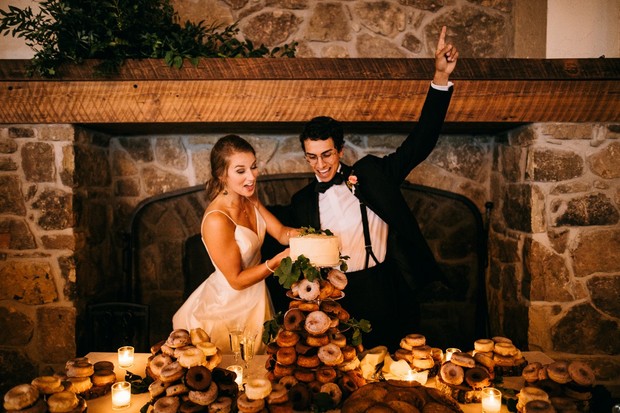 Newlyweds celebrate with cake and donuts at their wedding reception