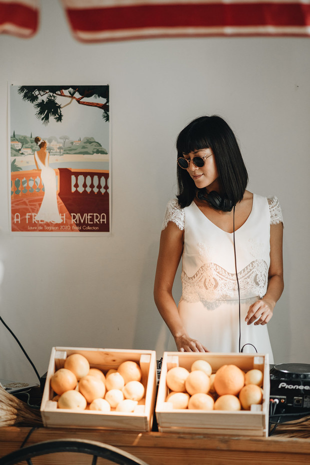 Woman DJ in white dress playing music with oranges
