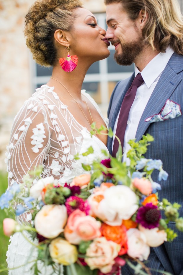 Bride and groom kissing at wedding ceremony with beautiful bouquet
