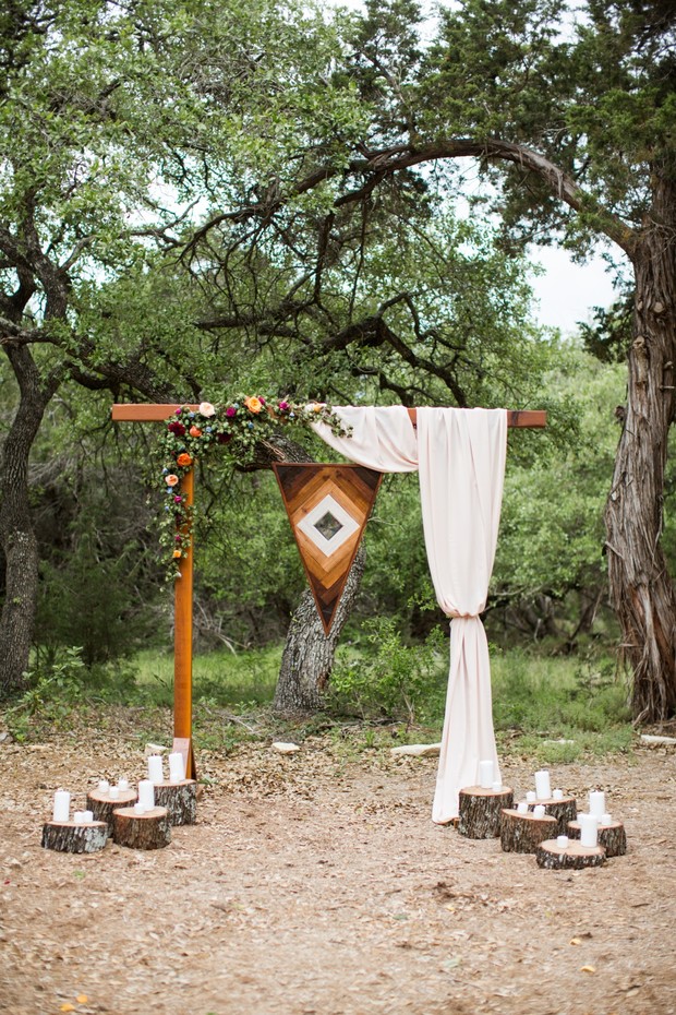 Rustic outdoor wedding ceremony arch with floral details