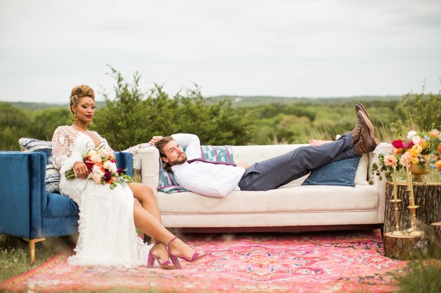 Relaxed bride and groom on outdoor couch during wedding day