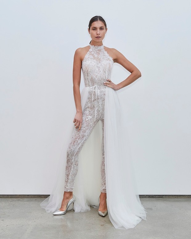 Elegant bride wearing lace wedding jumpsuit with a train