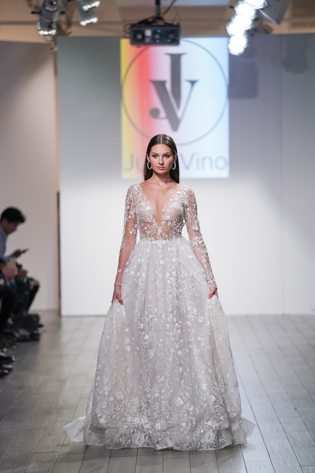 Stunning model wearing a delicate wedding dress on a runway
