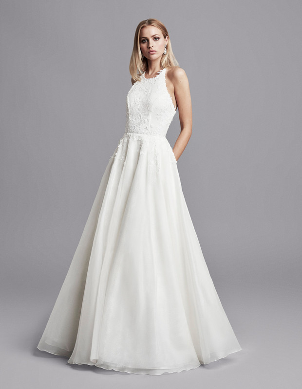 Elegant bride in a white wedding dress on a gray background