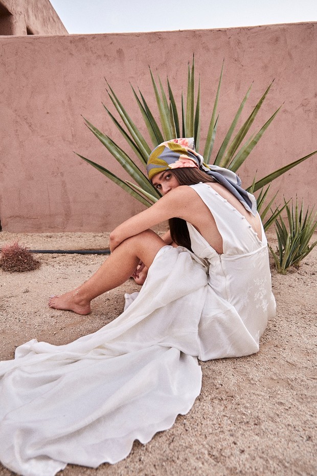 Woman in flowing white dress and headscarf in desert