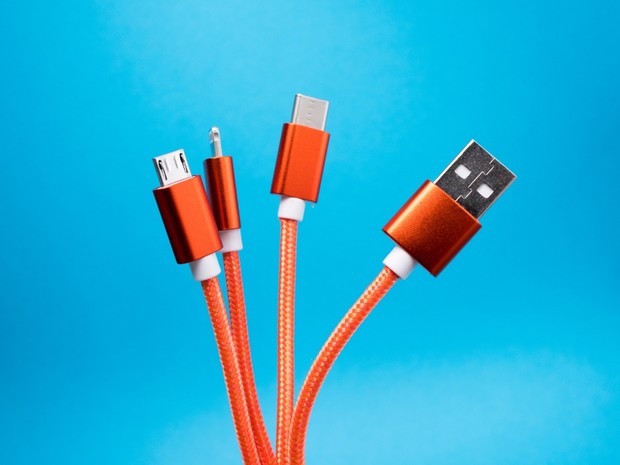 Orange USB cables on a bright blue background for charging devices