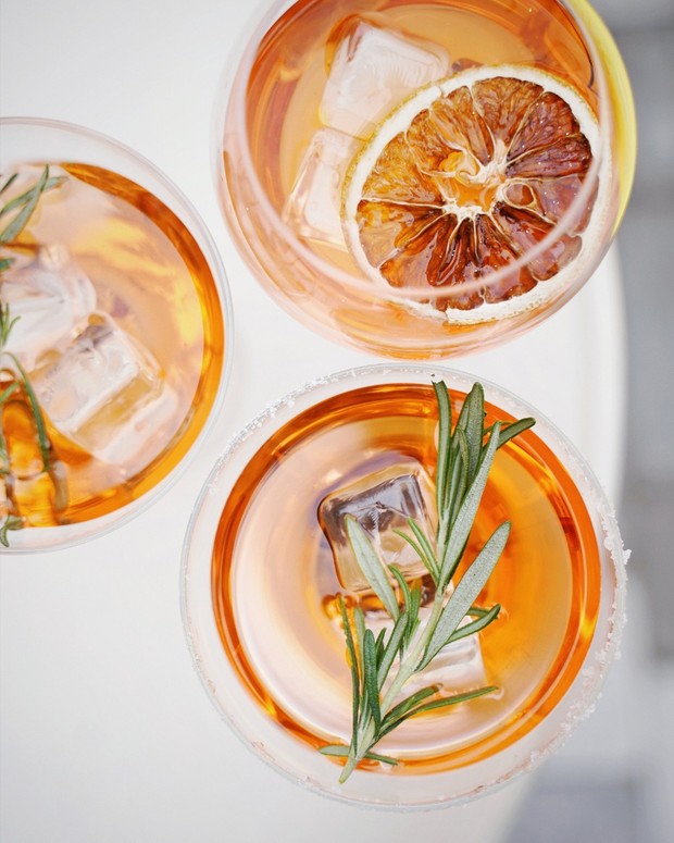 Three refreshing cocktails with rosemary and a dried citrus slice