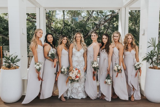 Bride with bridesmaids in elegant neutral-toned wedding dresses