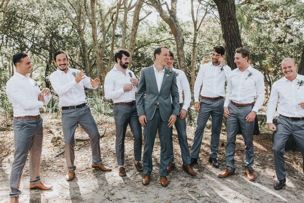 Groom with his groomsmen smiling and celebrating a wedding day