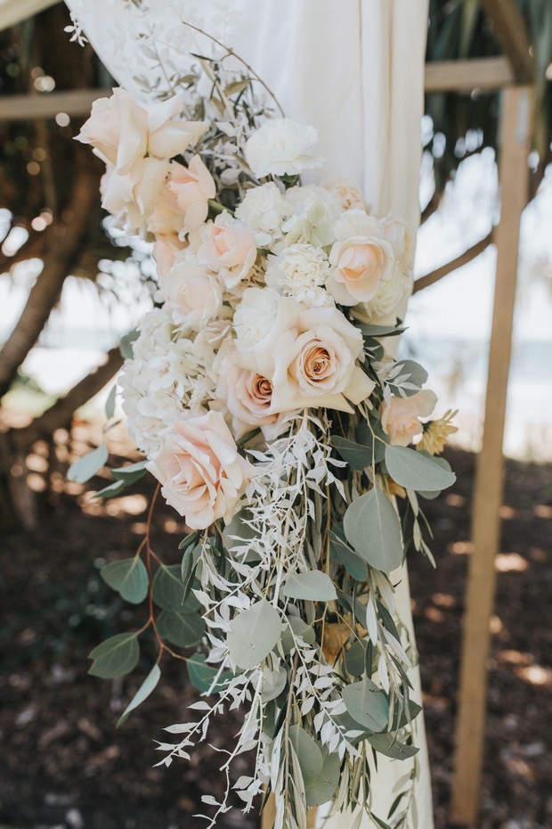 Elegant wedding arch decorated with blush and white floral arrangement