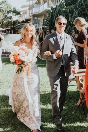 Bride and father walking down aisle at outdoor wedding